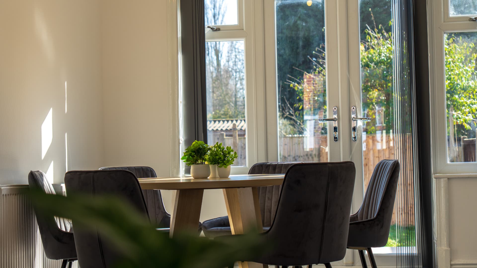 Sunlit round dining table with garden doors at Porlock, a Leicester serviced accommodation