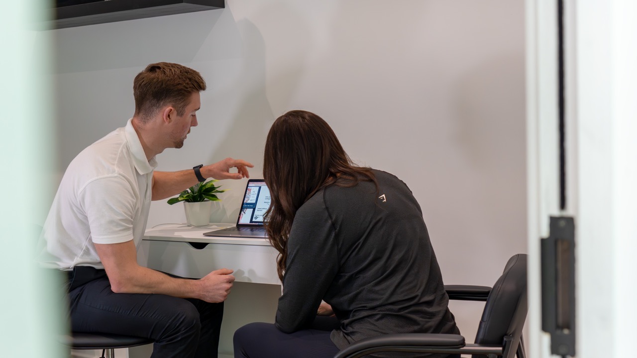 Physiotherapist talking a patient through her plan on a laptop