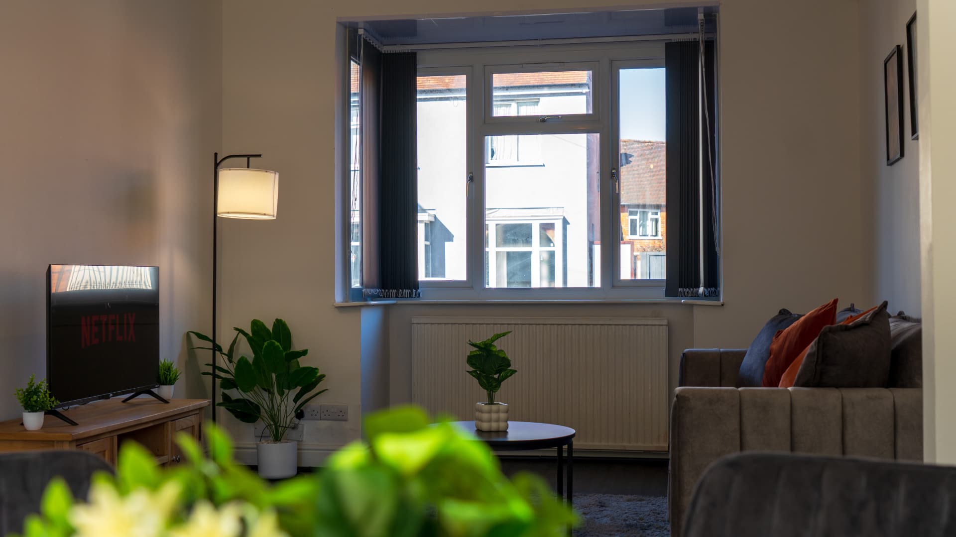 Guest lounge with bay window, floor lamp and smart TV at Porlock, Leicester