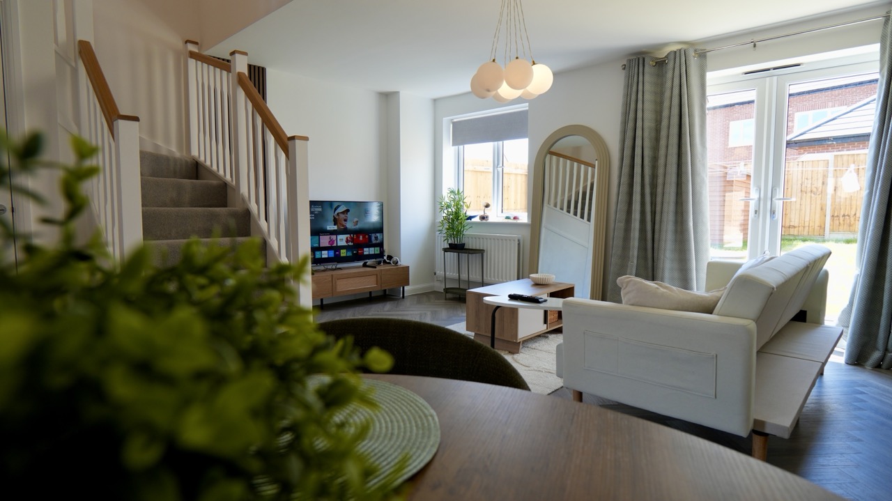 Living space with sofa, TV and garden doors in a Corby Airbnb