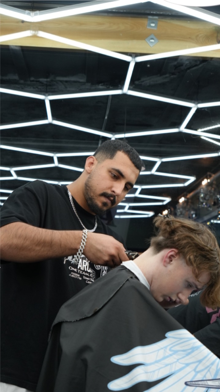 Barber lining up a fade under hexagon lighting at Tip Top Worthing