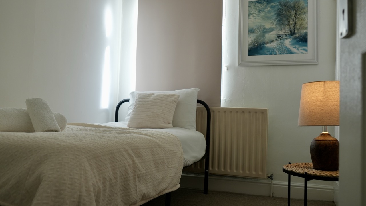 Bright twin bedroom with fresh towels in a Coventry serviced apartment
