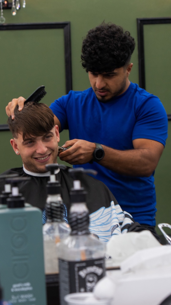 Client smiling in the chair mid-cut at Tip Top Worthing