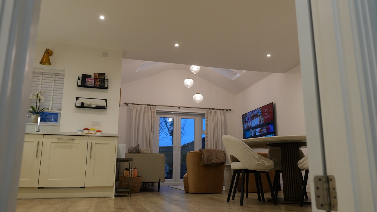 Open-plan kitchen and lounge extension lit for evening, Milton Keynes