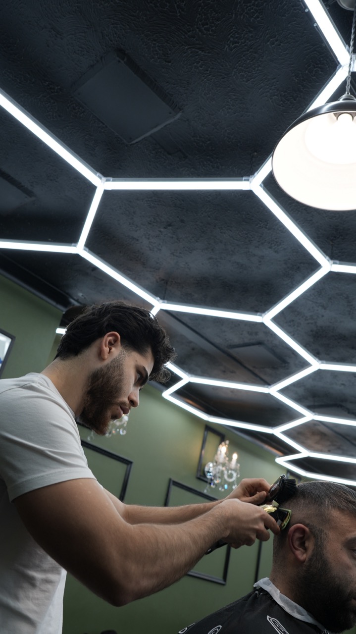 Barber clipper work framed by the shop's hexagon ceiling lights